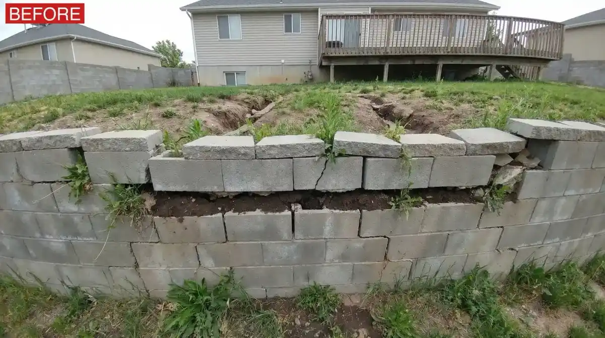 Before: failing leaning retaining wall in a residential backyard needing repair